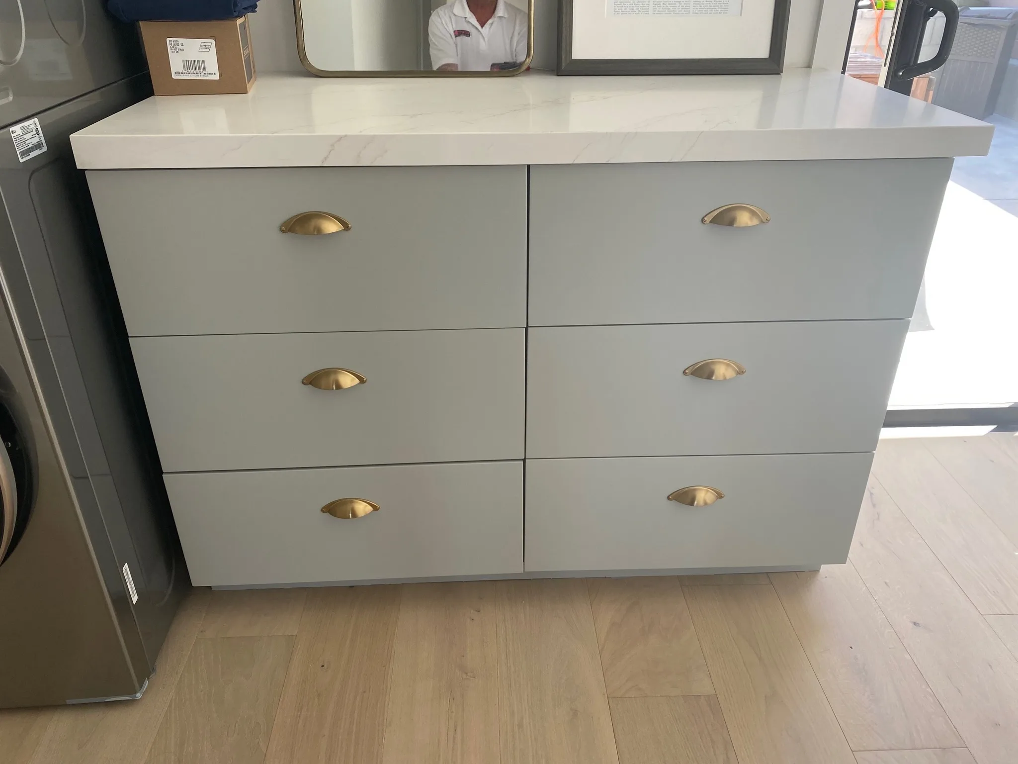 Greige cabinet drawers with brass cup pulls