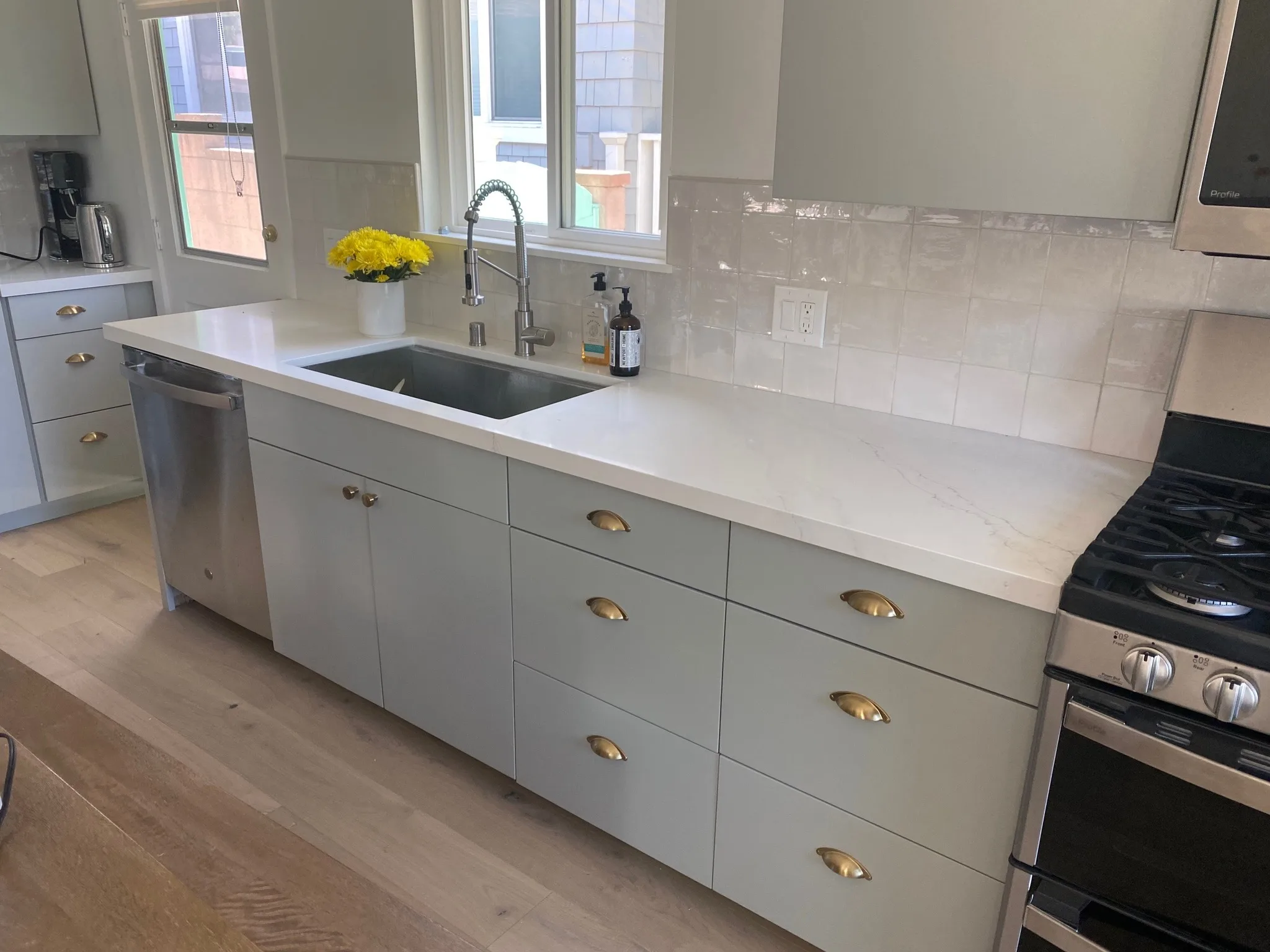 Cabinet run with brass hardware and farmhouse sink