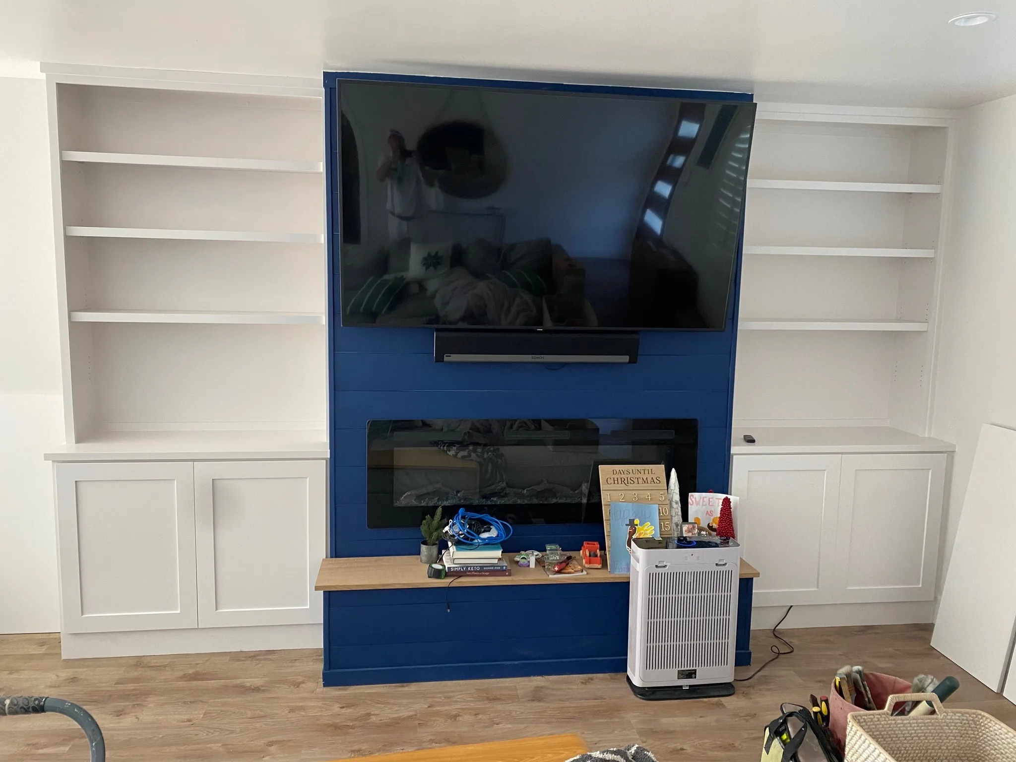 Navy built-in media wall with open shelving and fireplace