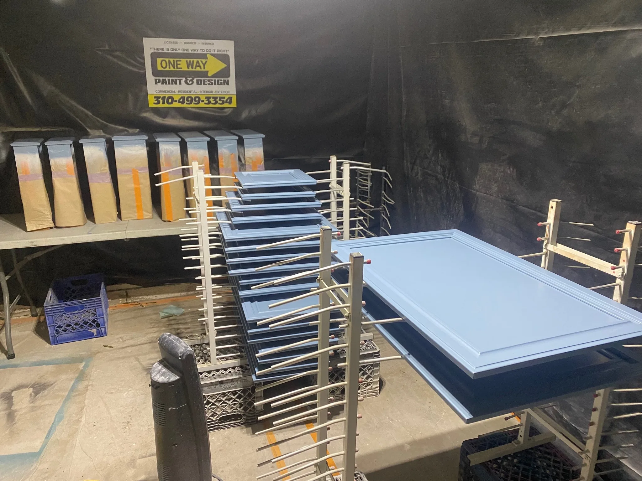 Cabinet door drying on a spray rack at the One Way shop
