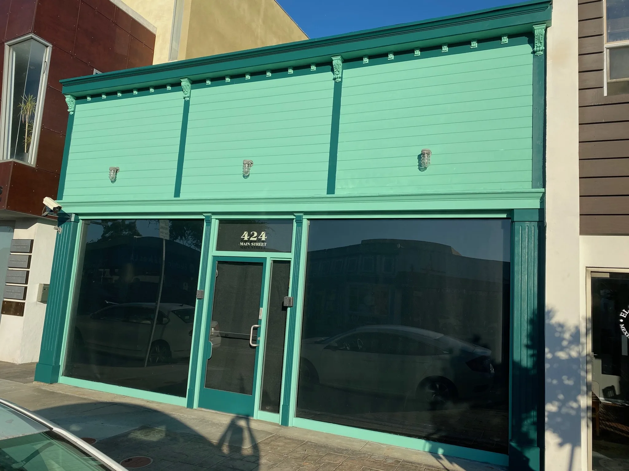Commercial storefront repainted in teal with fresh trim