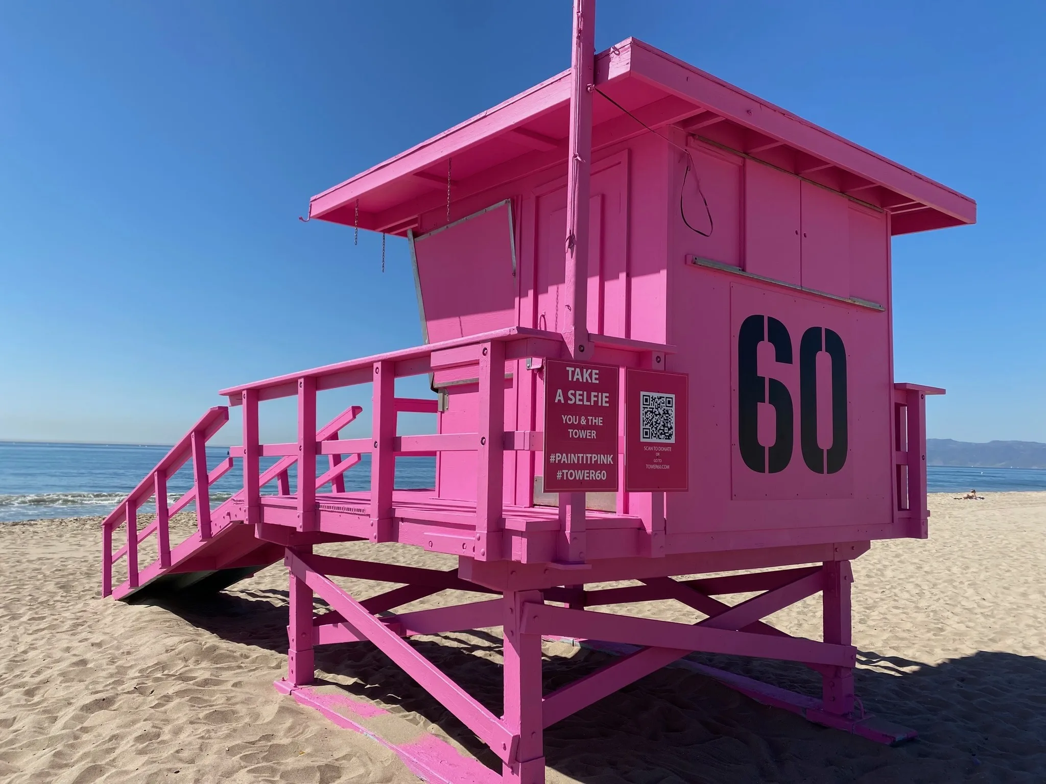 Freshly painted pink lifeguard tower on the sand