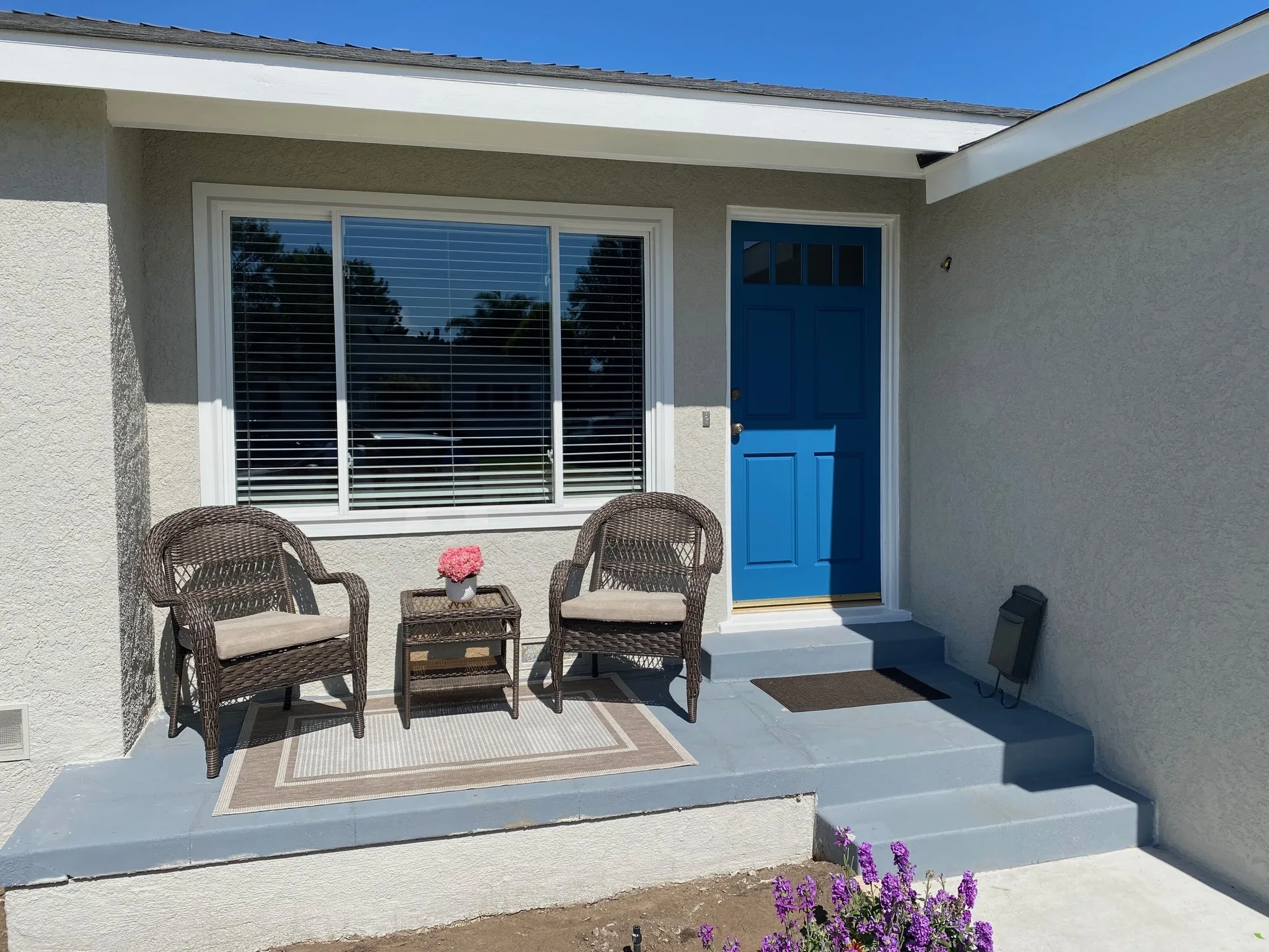 Porch refinished in gray with a repainted blue front door