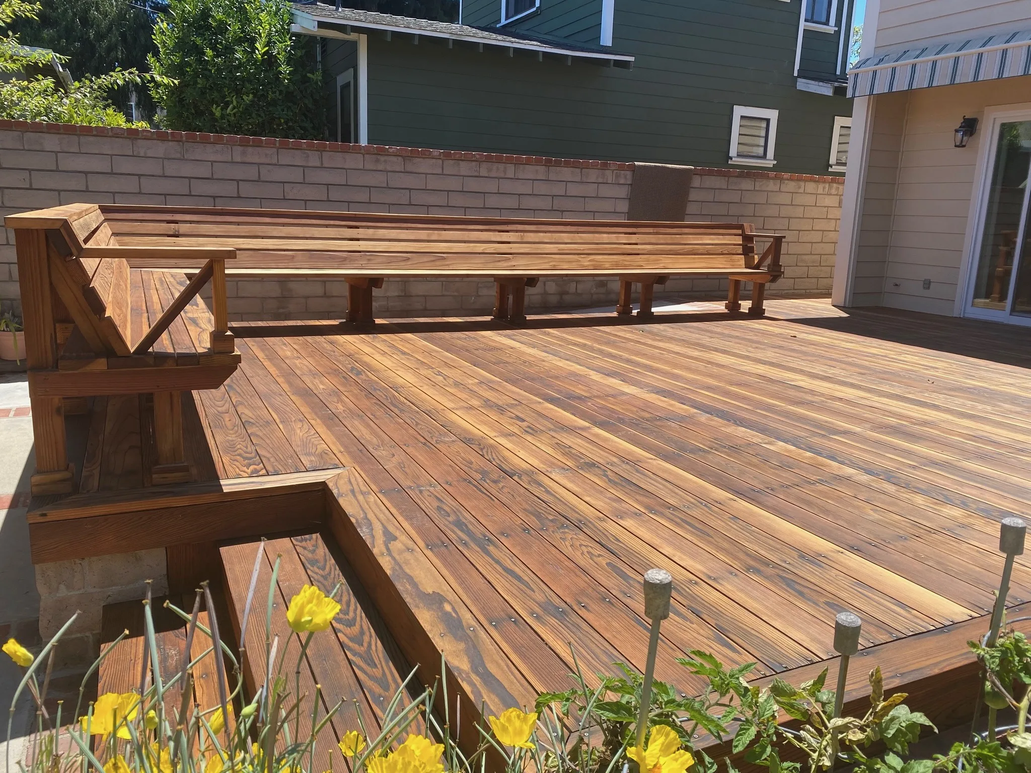 Natural wood deck refinished with built-in bench seating