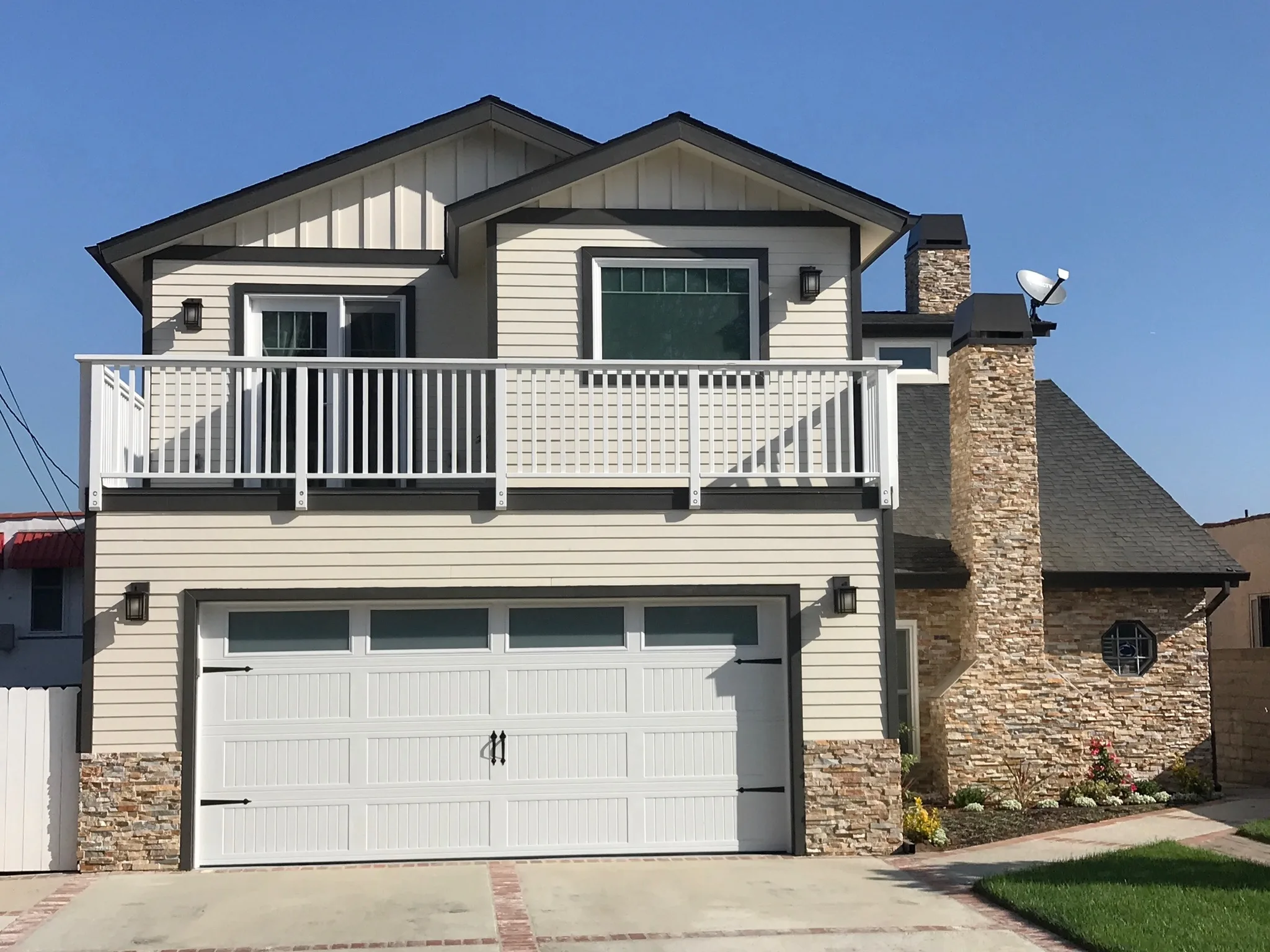 Two-story home with white siding and stone accents