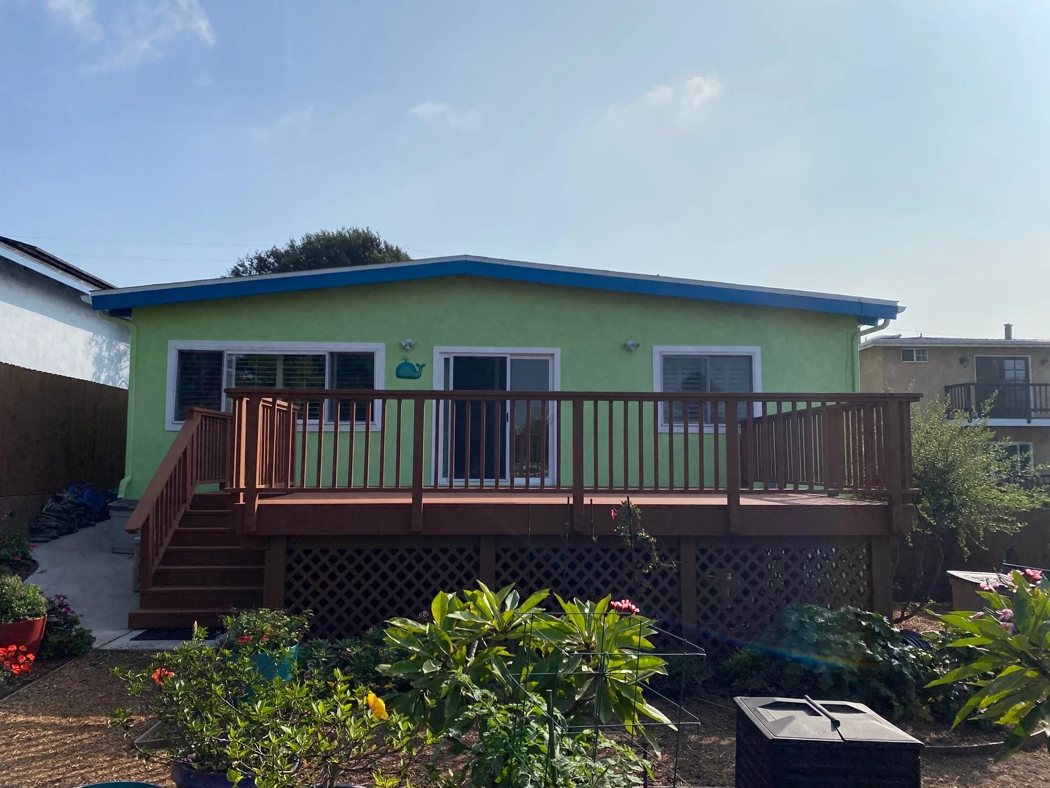 Green home exterior with refinished wood deck