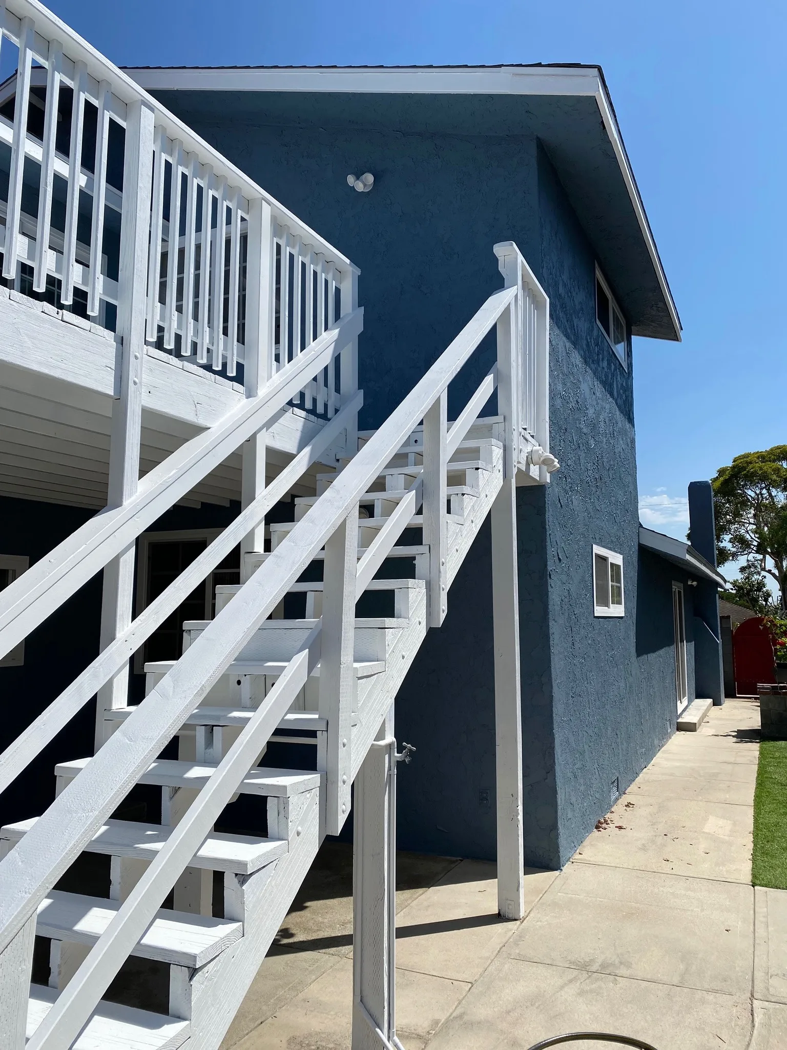 Dark blue home exterior with freshly painted white staircase