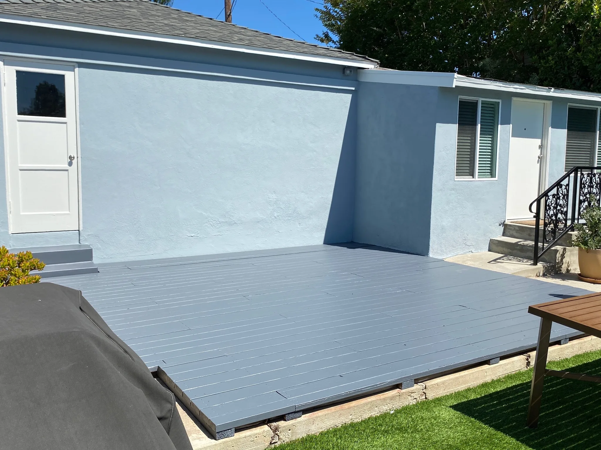 Blue home exterior with newly refinished gray deck