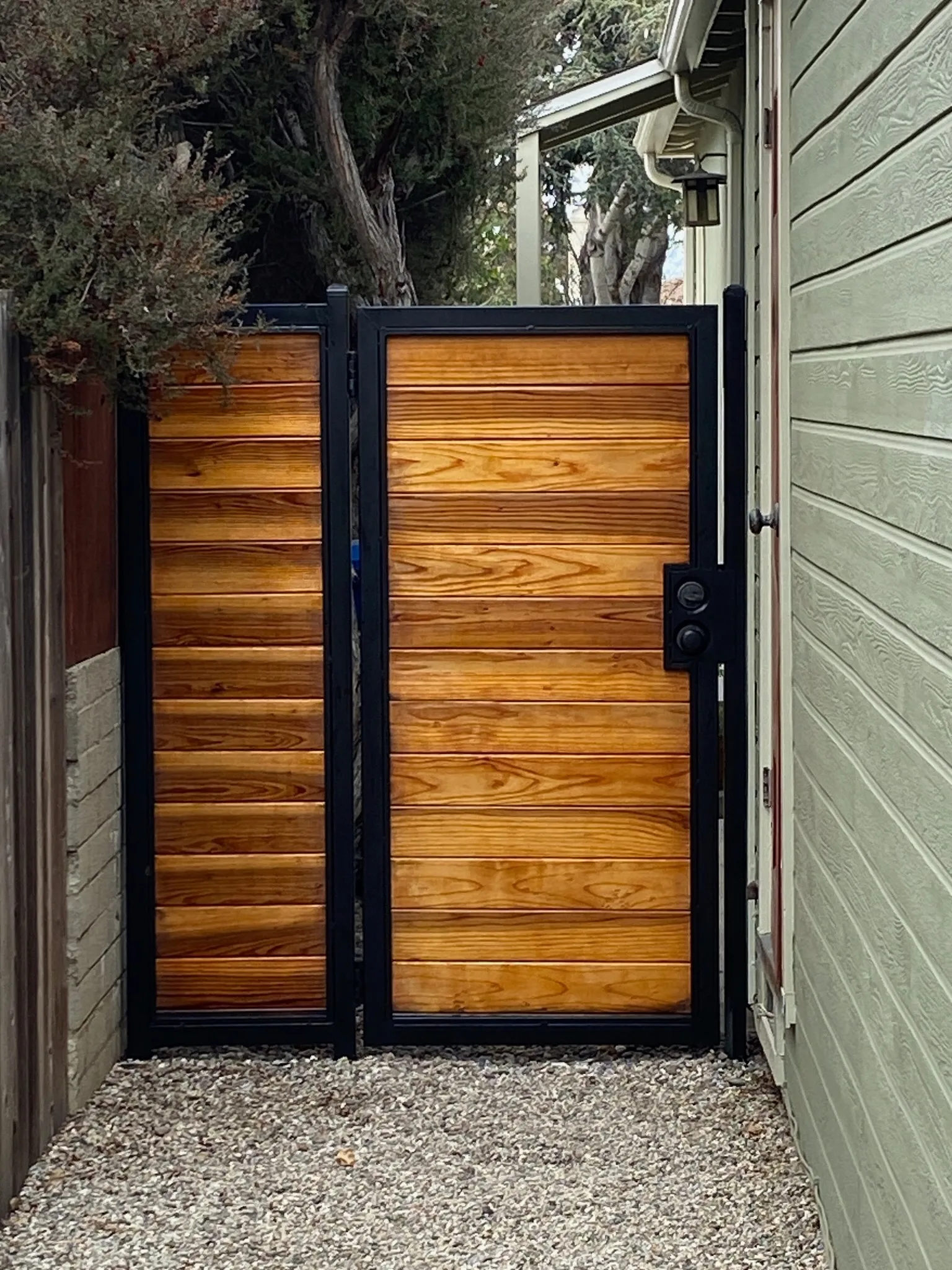 Custom wood gate with black steel frame, stained and sealed