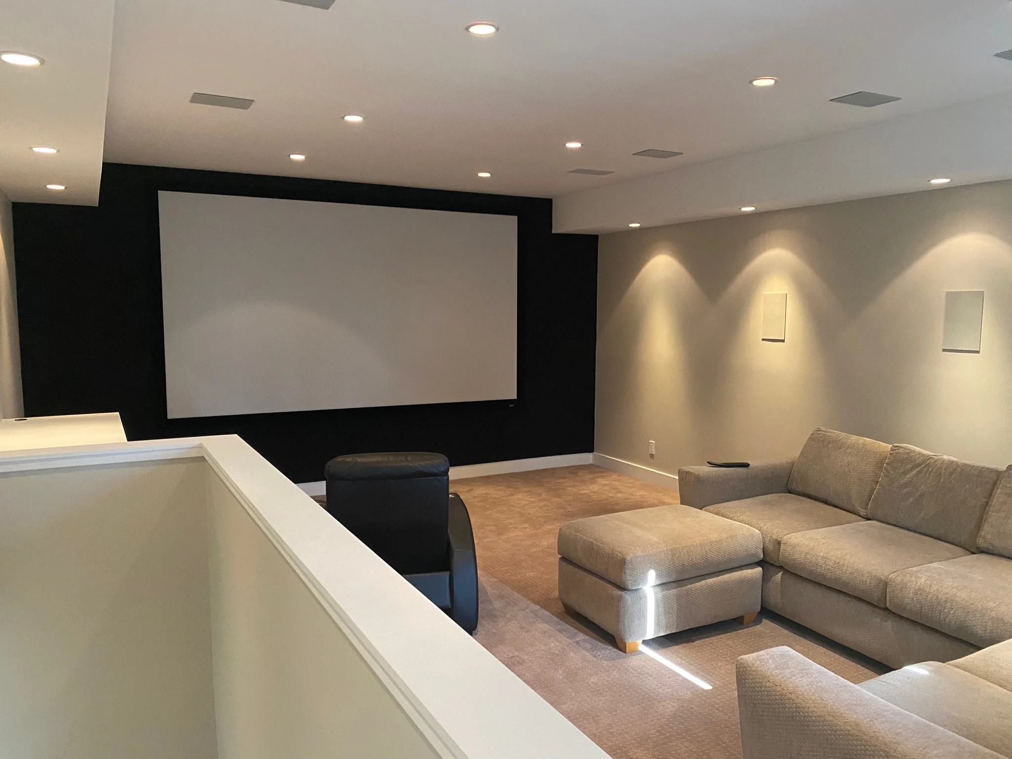 Home theater with black accent wall and recessed lighting
