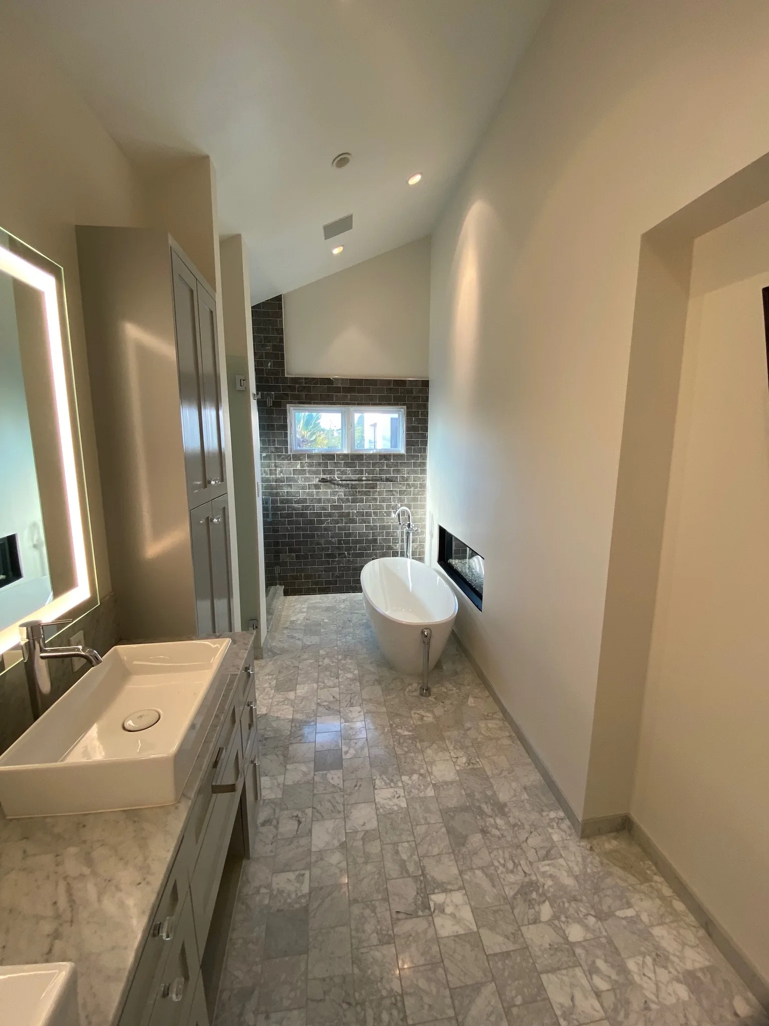 Bathroom with freshly painted walls, freestanding tub, and stone accents